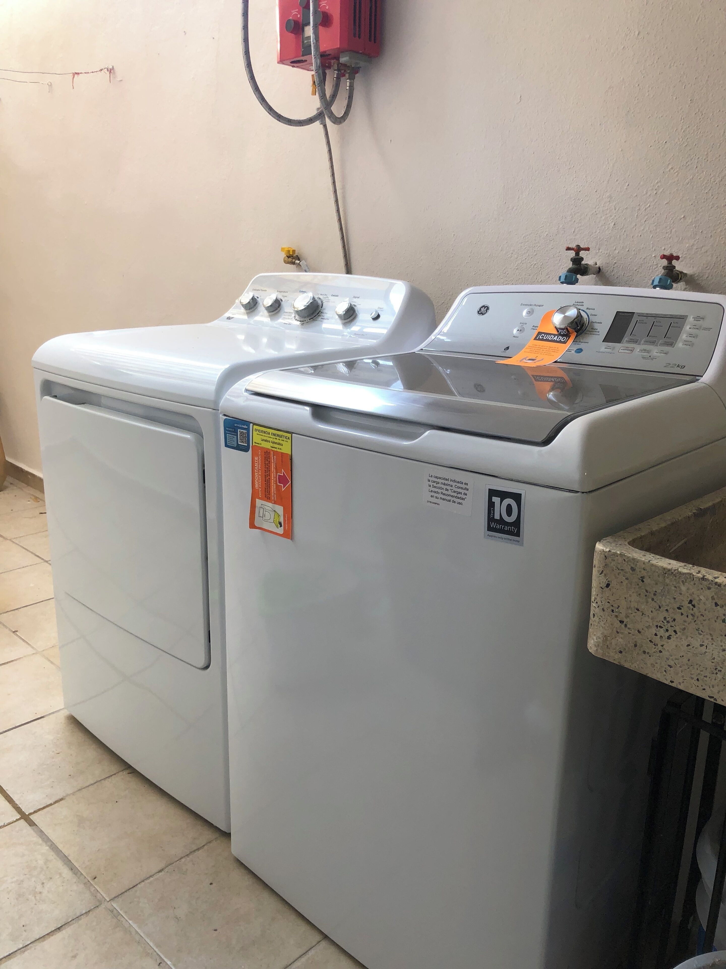 Een voorlader wasmachine met bedieningspaneel, een veiligheidslabel en een garantie sticker.