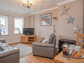 A living room with a sofa, a television, a fireplace, and decorative stars on the wall.