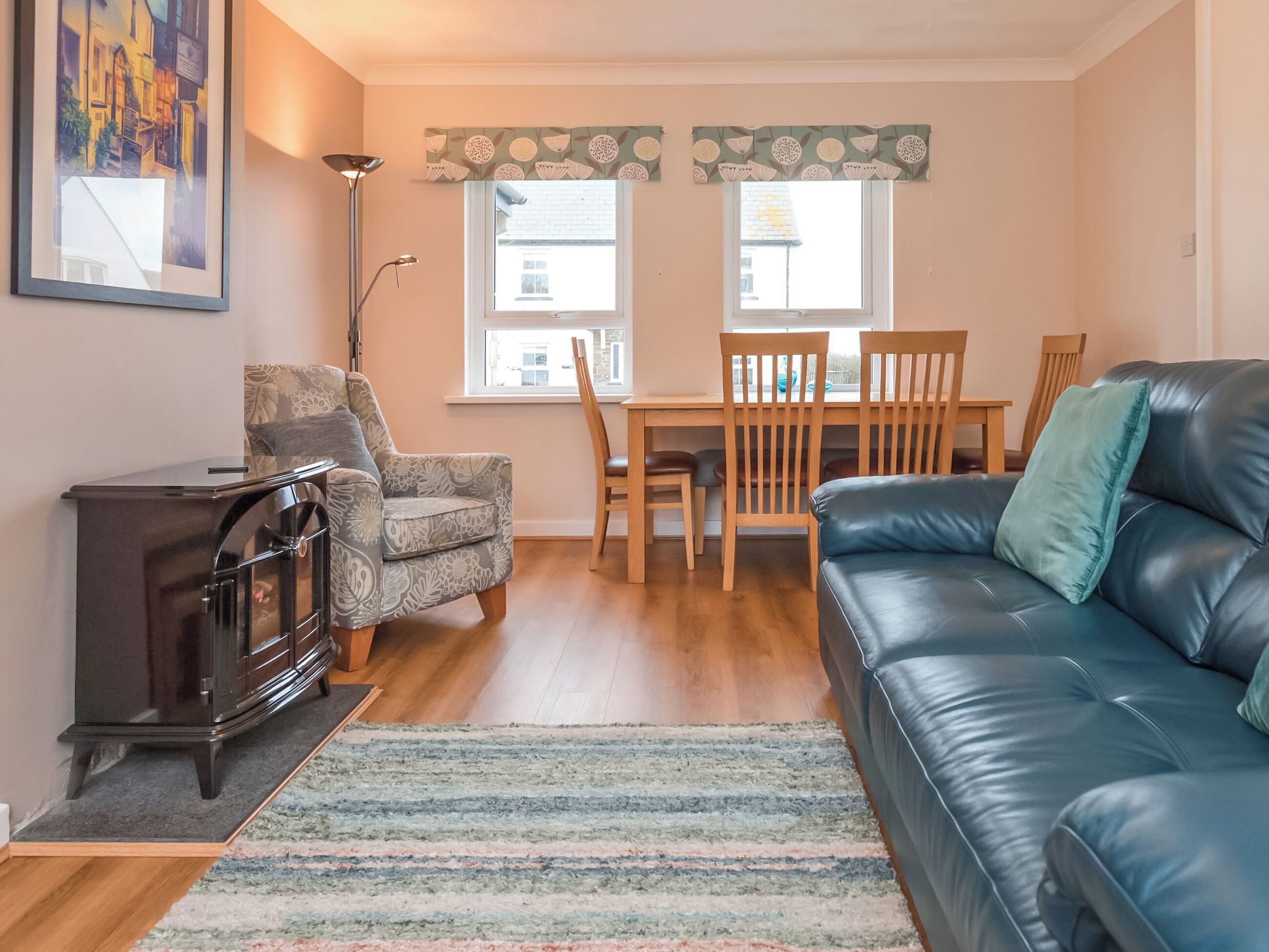 A living room with a sofa, a chair, a small table, a cabinet, and a rug.
