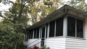 Une maison à deux étages dotée d’un porche abrité, de grandes fenêtres et d’un escalier menant à l’étage supérieur.