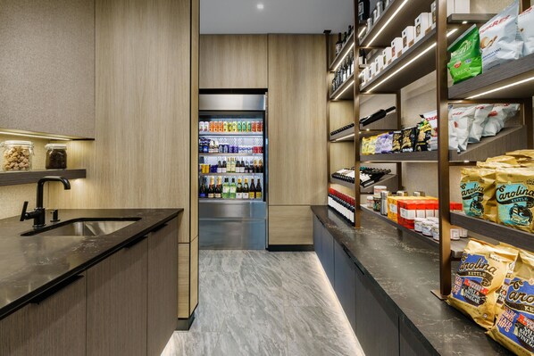 A modern kitchen with a marble countertop, built-in shelves, and a central island.