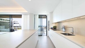 A modern kitchen with a long countertop, a sink, and a view of the outside. - Spectacular beachfront panoramic terrace (Torremolinos)