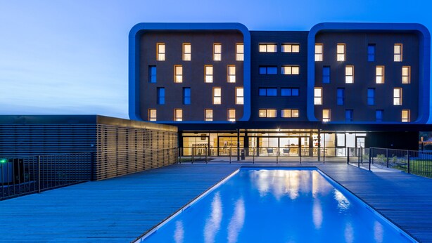 A modern building with a pool in front, featuring a unique architectural design with large windows and a flat roof. - The Originals City, Hôtel Le Relais des Deux Mers, Marmande Sud (Samazan)