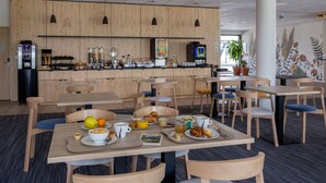 A modern cafe with wooden furniture, a variety of breakfast options, and a visible coffee machine. - The Originals City, Hôtel Le Relais des Deux Mers, Marmande Sud (Samazan)