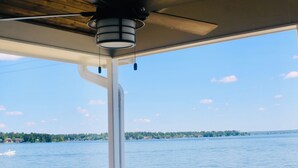 A covered outdoor area with a view of the water, a ceiling fan, and a railing. - Lakefront-April Sound -Hot tub bath with Panoramic lake view- Fish off the dock (Montgomery)