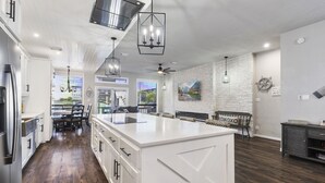 A spacious kitchen with a large island, white cabinetry, and a farmhouse-style ceiling. - Lakefront-April Sound -Hot tub bath with Panoramic lake view- Fish off the dock (Montgomery)