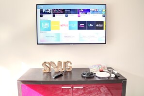Een televisie aan de muur met verschillende streaming apps.