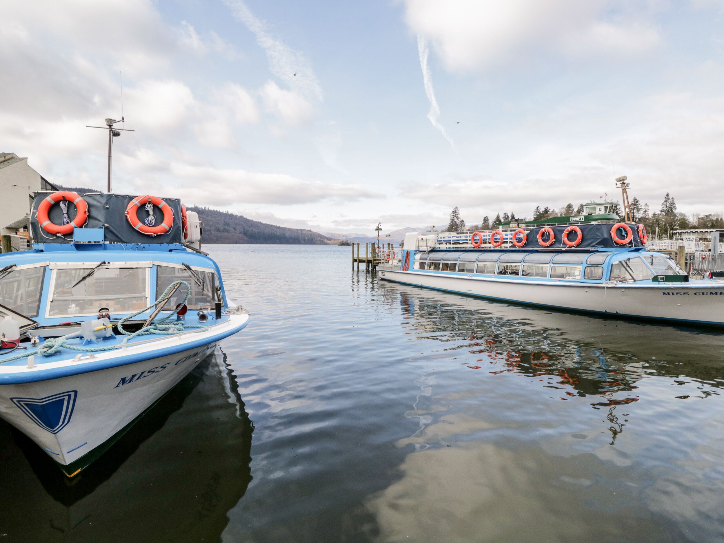 Zwei Boote liegen an einem Jachthafen fest, mit Rettungsringen an den Seiten.