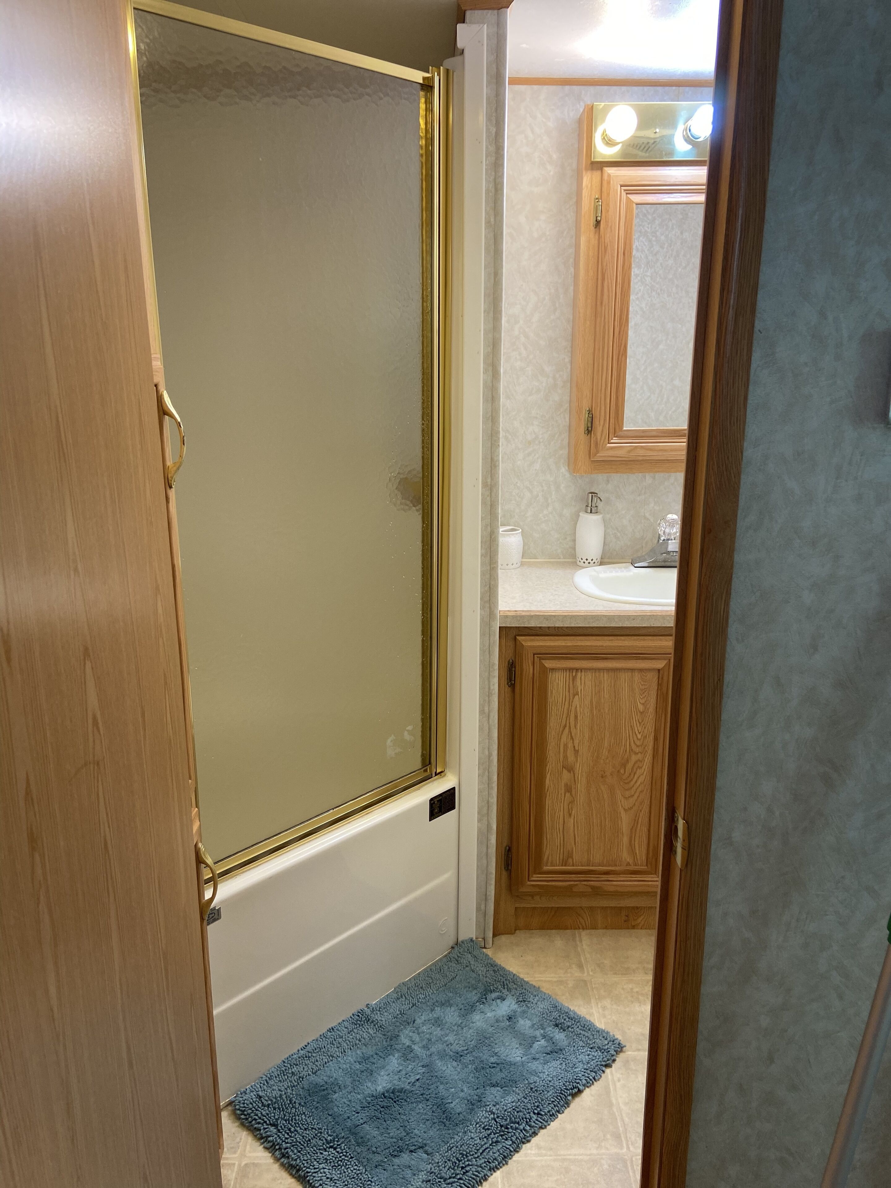 A bathroom with a shower, a sink, and a mirror.