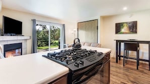 Eine moderne Küche mit Gaskochfeld, Flachbildfernseher und Kamin.