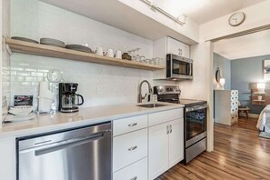 Eine moderne Küche mit Edelstahlgeräten, einer Mikrowelle und einer Kaffeemaschine.