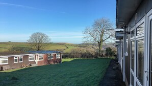 Une maison avec vue sur des collines ondoyantes et un ciel dégagé.