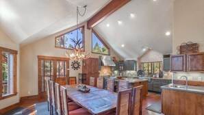 Una cocina amplia con una isla grande, armarios de madera y un comedor con una mesa larga y sillas.