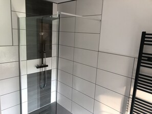 Chuveiro, toalhas de banho, sabonete, papel higiênico