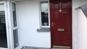 A red door with a brass handle and a small window above it. - Immaculate 3-bed Apartment in Kilkenny (Kilkenny)