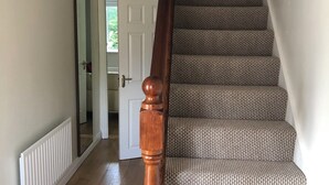 A staircase with a wooden handrail and patterned carpet. - Immaculate 3-bed Apartment in Kilkenny (Kilkenny)
