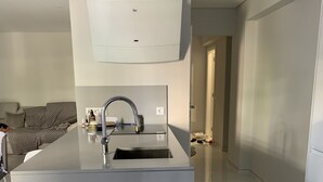 Une cuisine moderne dotée d’un îlot central, d’un évier encastré et d’un robinet en acier inoxydable.