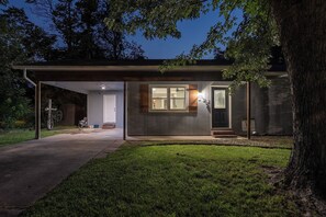 Una casa moderna con un porche cubierto, garaje y un césped cuidado.
