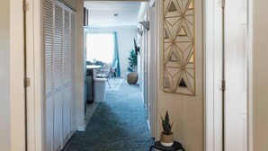 A hallway with a dark carpet, white doors, and a decorative wall piece. - Boho 3 Bed Condo Near ETSU 102 (Johnson City)