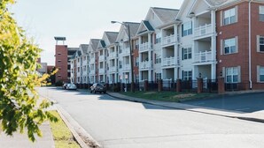 A row of townhouses with balconies, a brick facade, and a clear sky. - Boho 3 Bed Condo Near ETSU 102 (Johnson City)