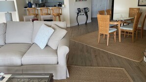 Una sala de estar con sofá, mesa de centro y comedor con sillas y mesa.