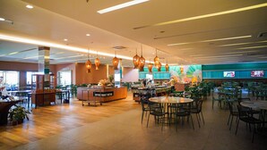 Un restaurant spacieux doté d’un comptoir central, de plusieurs espaces de restauration et de luminaires suspendus.