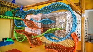 Un espace de jeux équipé de diverses structures d’escalade et d’obstacles en filet.
