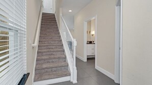 A staircase with a carpeted finish, white railings, and a light-colored wall. - 3 bed Modern Town Home On a Luxury Development Close to Disney (Clermont)