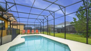 An indoor swimming pool with a clear view of the surrounding houses through a glass enclosure. - Modern 4  Bedroom Providence Villa Close To Disney (Davenport)