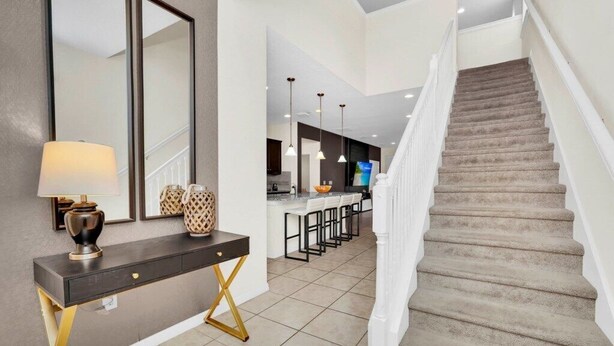 Un interior moderno con una escalera, una zona de cocina y un comedor.
