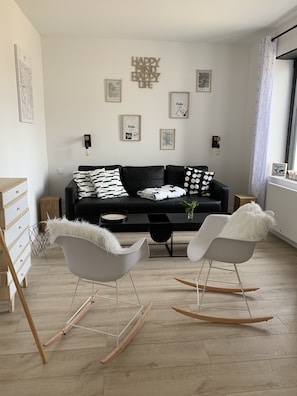 A modern living room with a black sofa, two rocking chairs, and a coffee table. - Cabana Lampaul (Lampaul-Plouarzel)