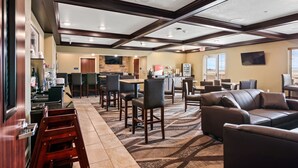 Un hall d'hôtel avec un bar, des sièges et une cuisine en arrière-plan.