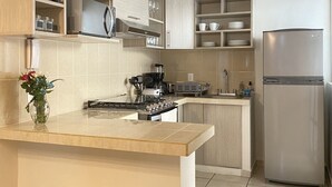 A modern kitchen with a central island, stainless steel appliances, and light wood cabinetry. - LUNA • Calm 2BR 2BA Apartment • Fast WiFi • Spacious Stay (Puerto Vallarta)