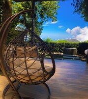 Una silla de mimbre con cojines en un entorno exterior.