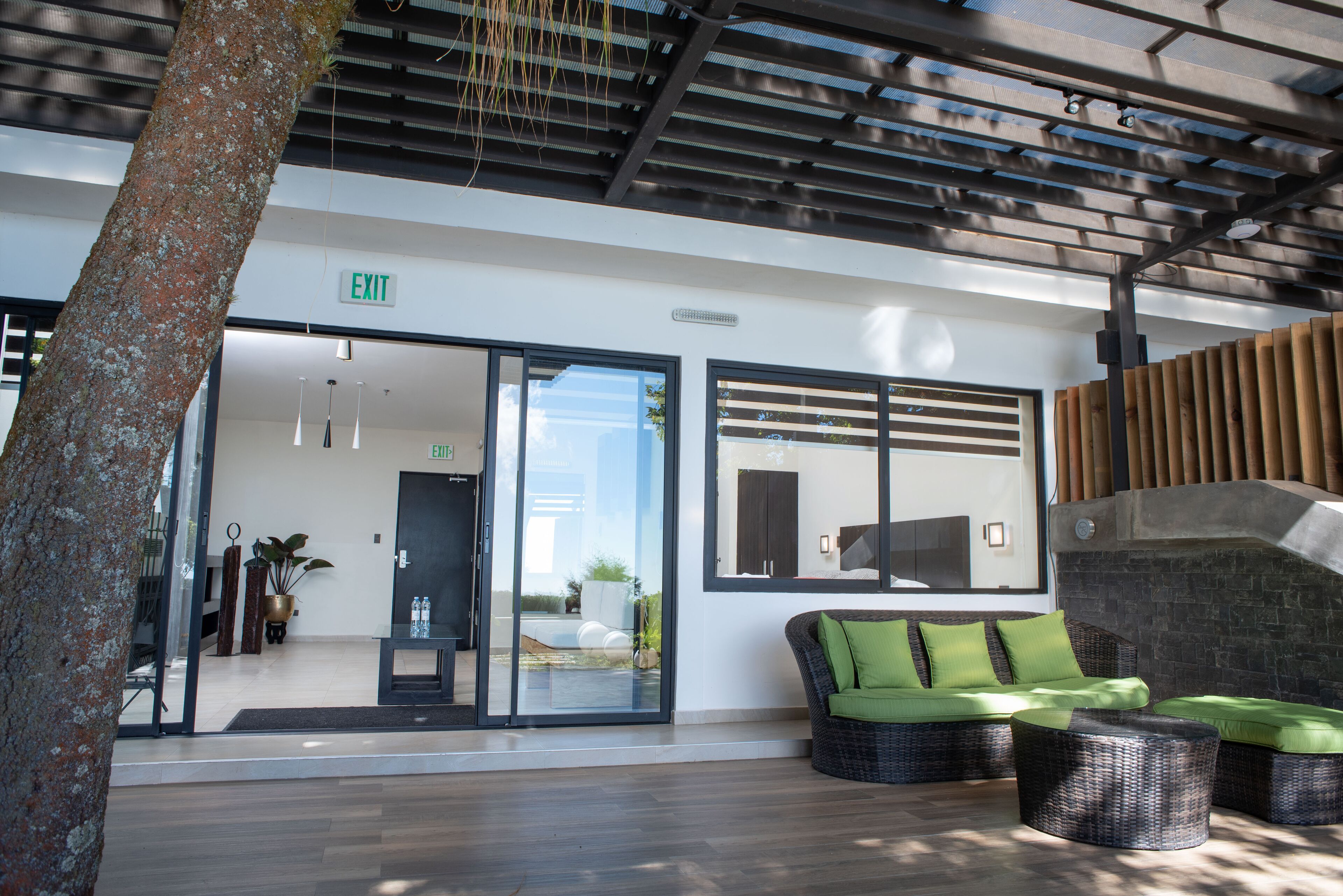 An outdoor seating area with wicker furniture and a glass door entrance.