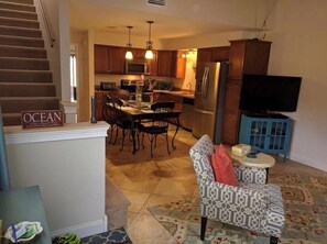 Relax in this open-plan living area with a kitchen, dining space, and staircase leading to an upper level.