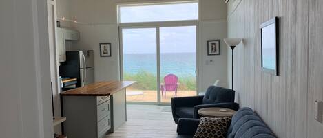Een modern interieur met een keuken, een bank en uitzicht op de oceaan.