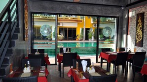 A restaurant with outdoor seating, a pool view, and a staircase. - Buasri Boutique Patong (Patong)