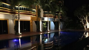 A modern hotel with a swimming pool, multiple balconies, and outdoor lighting. - Buasri Boutique Patong (Patong)