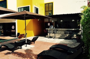 An outdoor seating area with lounge chairs and a bar counter.