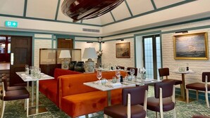 Un restaurante con cabinas y mesas, techo de madera y un cuadro en la pared.