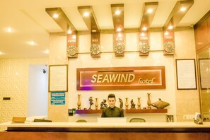 A reception desk at the Seawind Hotel with clocks displaying times for New York, Paris, London, and Tokyo. - Sea Wind Hotel (Da Nang)