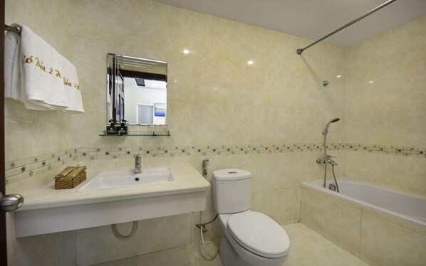 A bathroom with a sink, toilet, and bathtub.