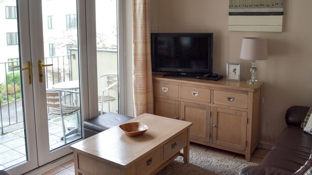 A living room with a television, a table with a bowl, a sofa, a lamp, and a cabinet. - Pine Rigg - Quarry Rigg (Bowness-on-Windermere)