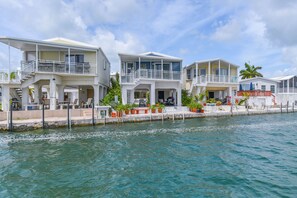 A waterfront property with multiple levels, outdoor seating, and a dock.