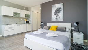 A modern bedroom with a large bed, bedside tables, a bedside lamp, and a gray abstract painting on the wall. - Apartments Zoom Zoom-Studio Apartment with Balcony (Grey) (Dubrovnik)