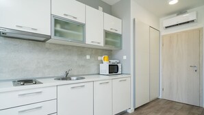 A modern kitchen with white cabinets, a microwave, and a sink. - Apartments Zoom Zoom-Studio Apartment with Balcony (Grey) (Dubrovnik)