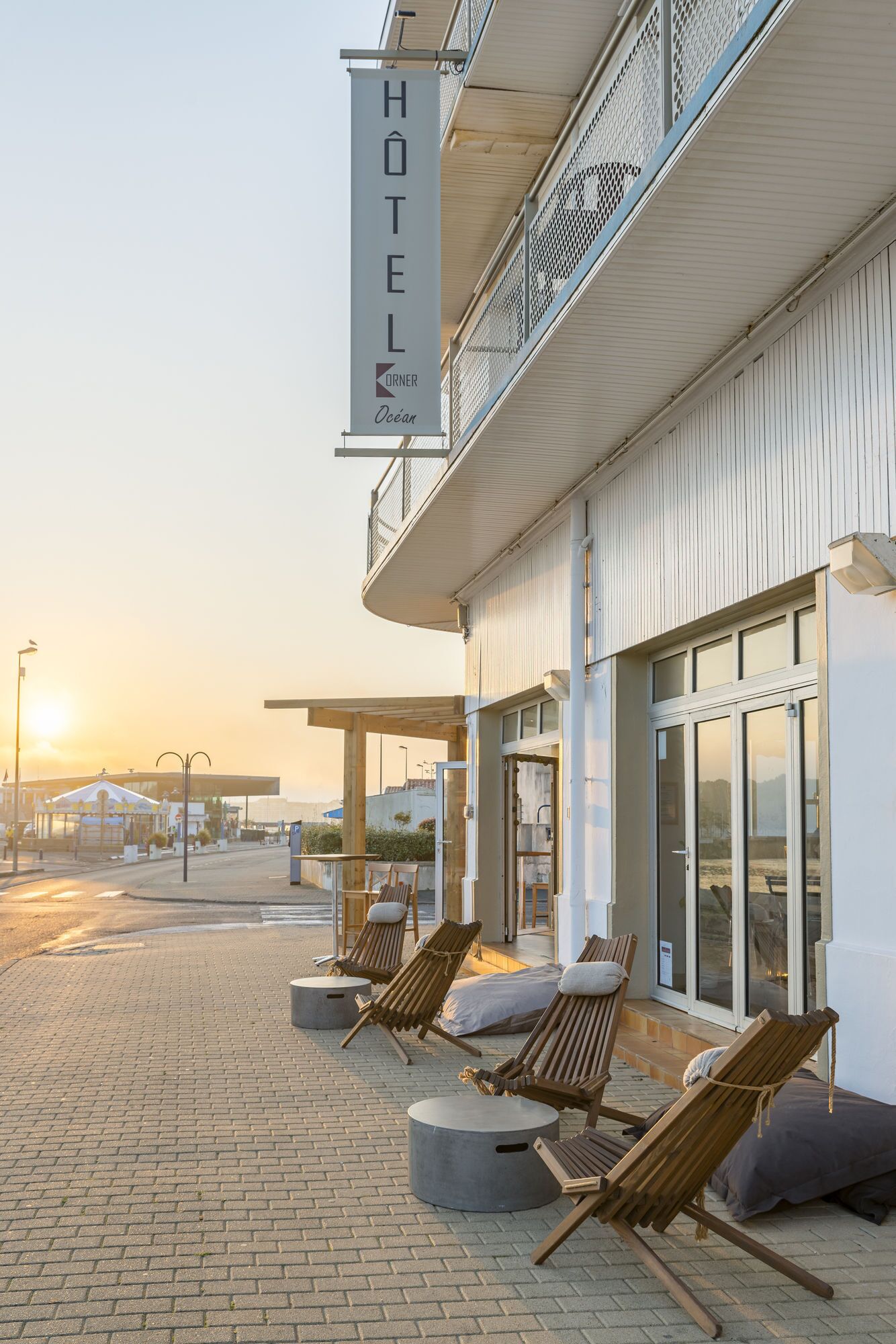 Un hôtel doté d’un balcon, de chaises longues et d’une enseigne indiquant qu’il s’agit d’un hôtel.