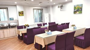 A dining area with multiple tables and purple chairs, a buffet station, and a window with a view of trees. - Greentree Inn Chongqing Longhushidai Tianjie Xietaizi Subway Station H (Chongqing)