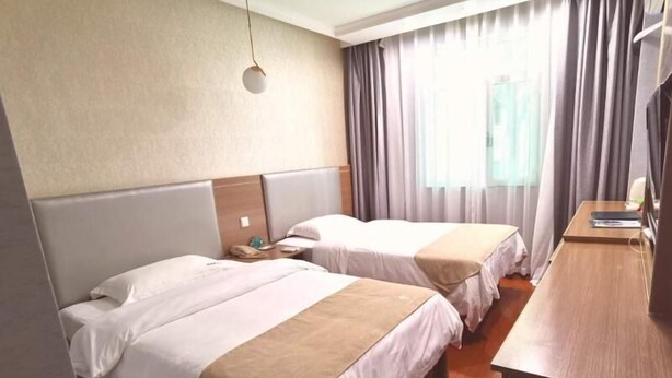 A hotel room with two beds, a wooden desk, and a window with curtains. - Greentree Inn Chongqing Longhushidai Tianjie Xietaizi Subway Station H (Chongqing)